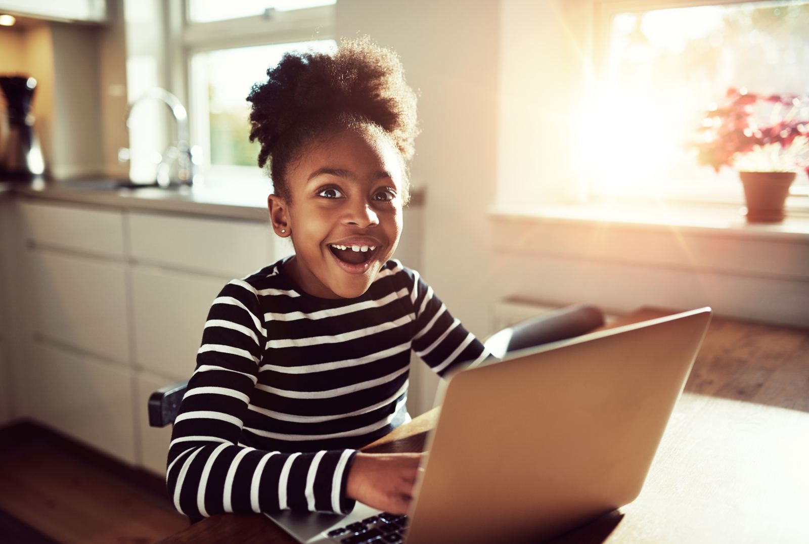 Student smiling while learning on a laptop